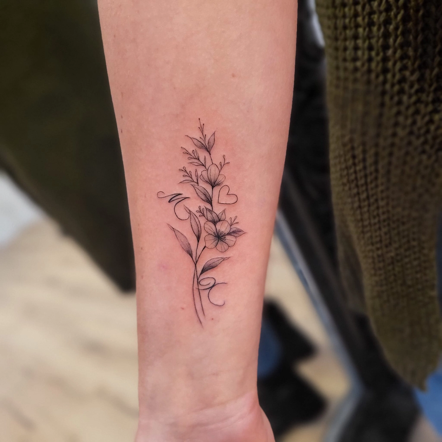 A Fleur de Peau - Professionelles Tattoo Studio - Tätowierung am Arm einer Person